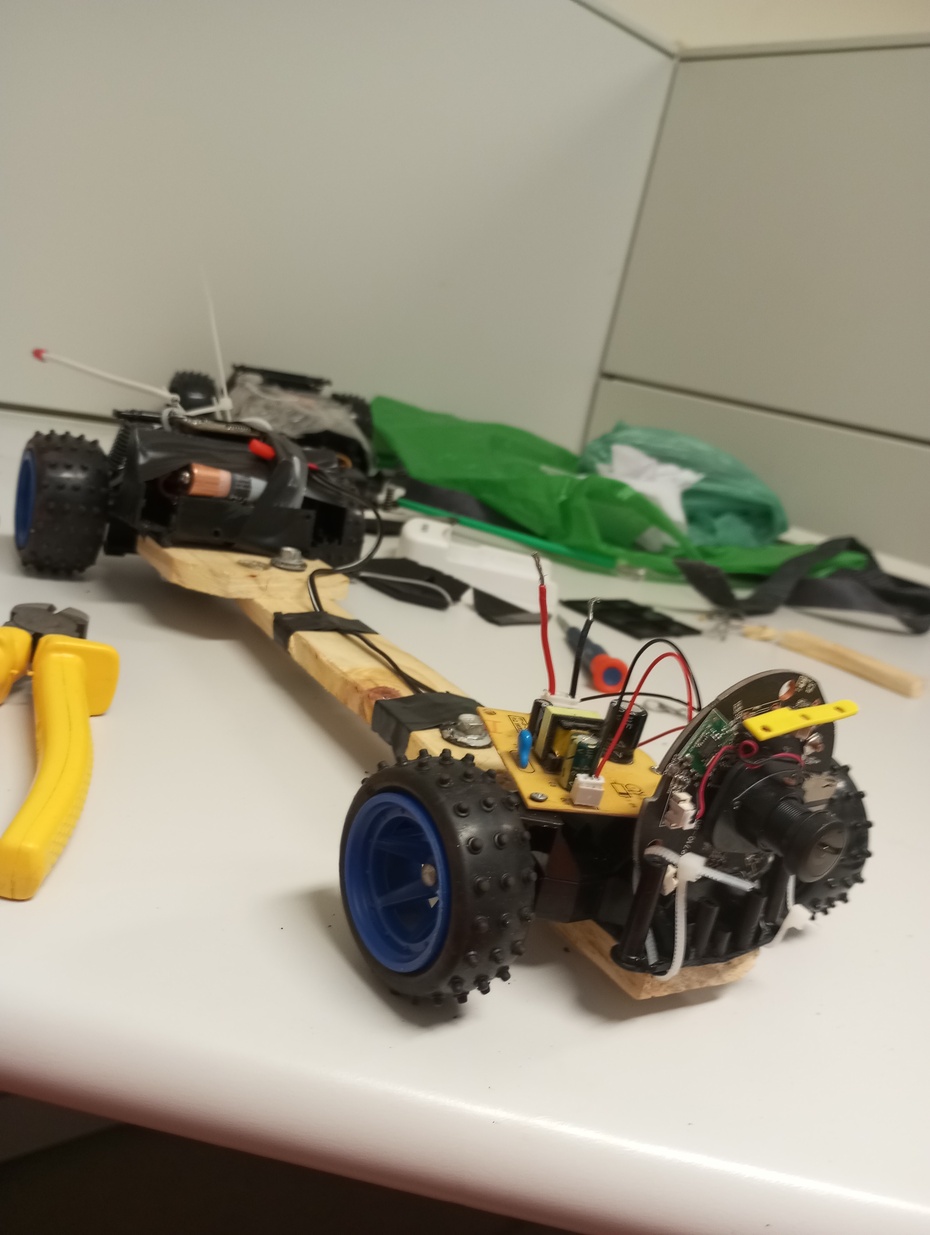 Tentamos entrar somente com a câmera, guia de nylon industrial, e nada...Tentamos adaptar um pedaço de madeira no carrinho robô, mas ele não virava as curvas, ficou grande demais.