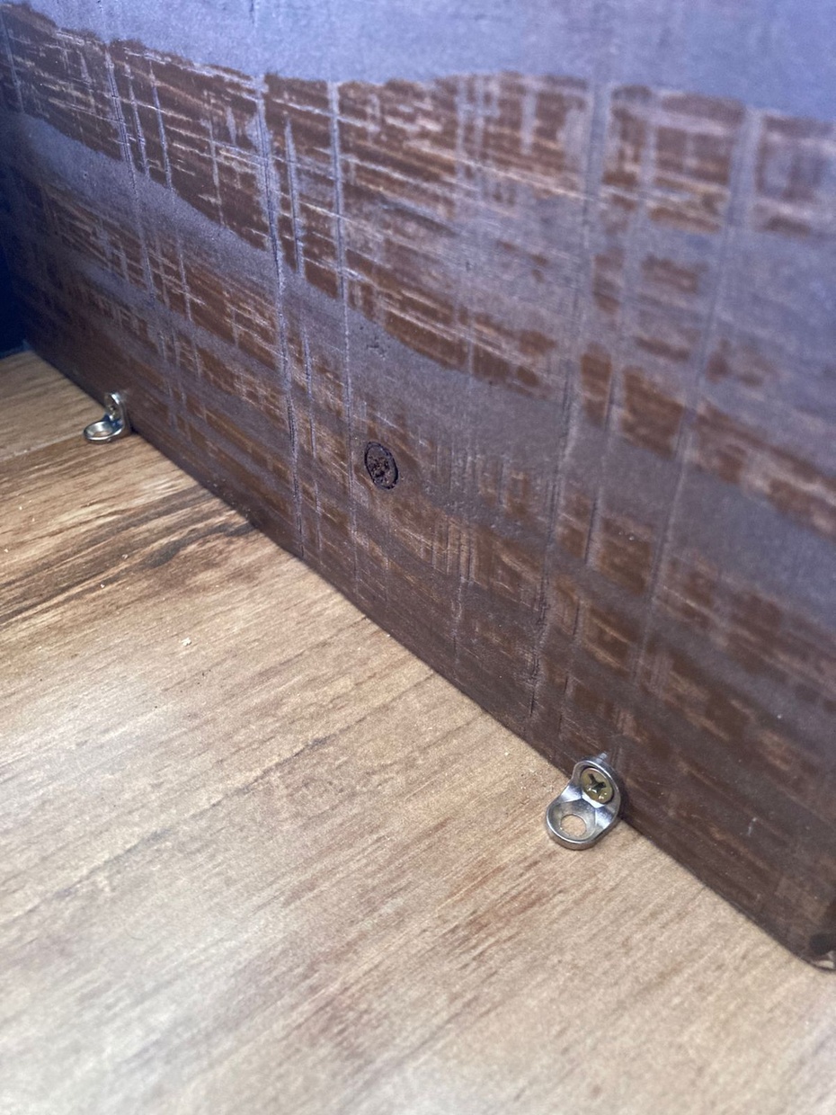 Com todas as peças parafusadas e coladas (se você não tiver cola de madeira, não tem problema), é hora de parafusar as cantoneiras cadeirinha. Apoie a prateleira no chão liso para facilitar a instalação das cantoneiras e garantir que fiquem rentes na hora de instalar na parede.