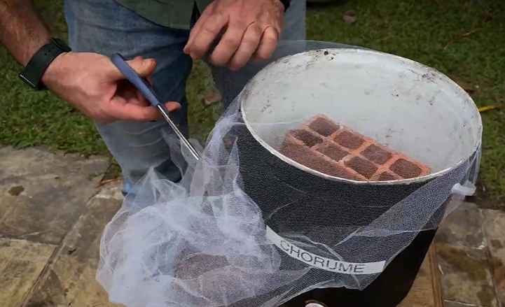 Coloque um tijolo pequeno dentro do coletor. Isso cria “refúgio” para minhocas que porventura caírem no chorume. Também coloque tule como proteção entre a tampa e o balde.