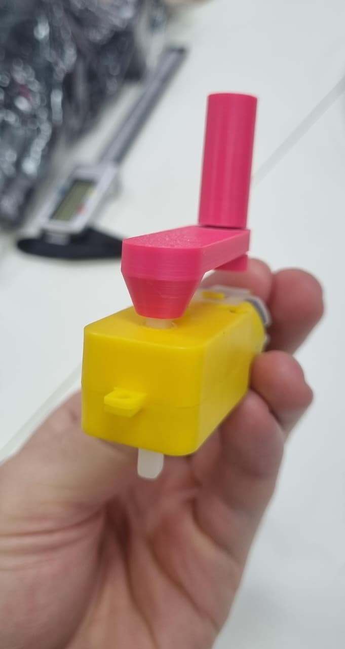 Encaixe o furo do braço no eixo do motor (a parte branca que gira). A manivela deve ficar bem justa, para se manter fixa sem o uso de cola. Caso ela esteja justa ou folgada demais, volte ao primeiro passo e ajuste as dimensões do furo.