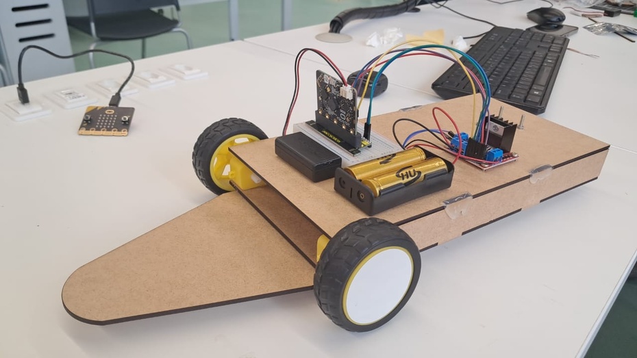 Construção mecânica: colagem das peças cortadas em MDF na cortadora a laser, e dos componentes, como motor elétrico pequeno, protoboard, suporte das baterias com cola quente e utilização dos parafuso e porcas pequenas para prender a roda giratória e a ponte H.