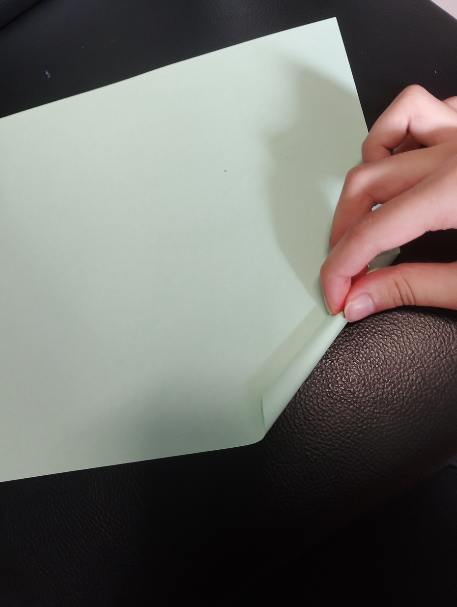 Enrole a folha verde na diagonal de forma que fique bem fininha