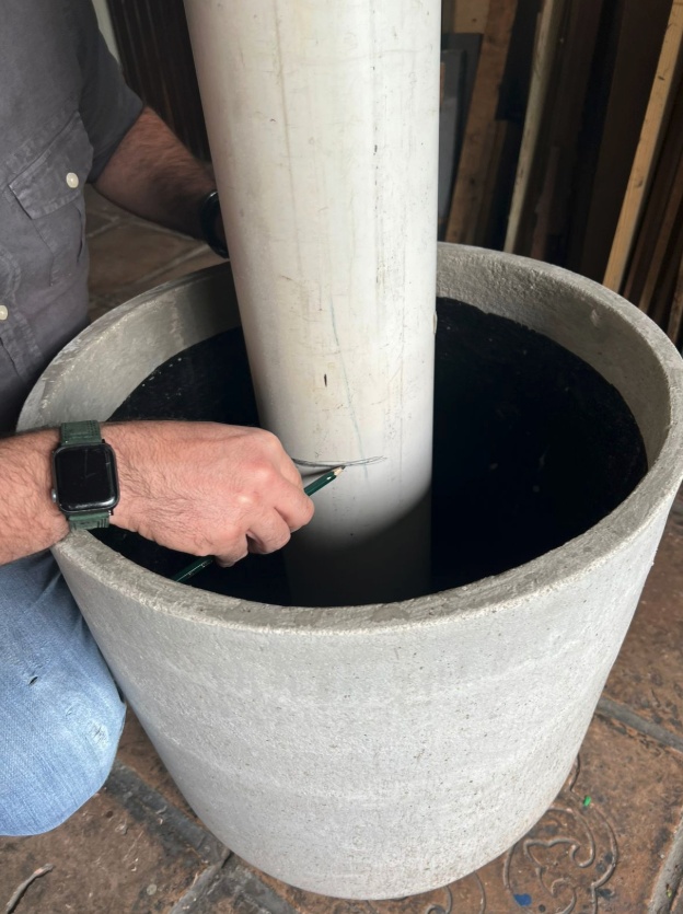 Apoie o cano de PVC verticalmente dentro do vaso e marque no cano o nível da terra até onde o vaso será preenchido.