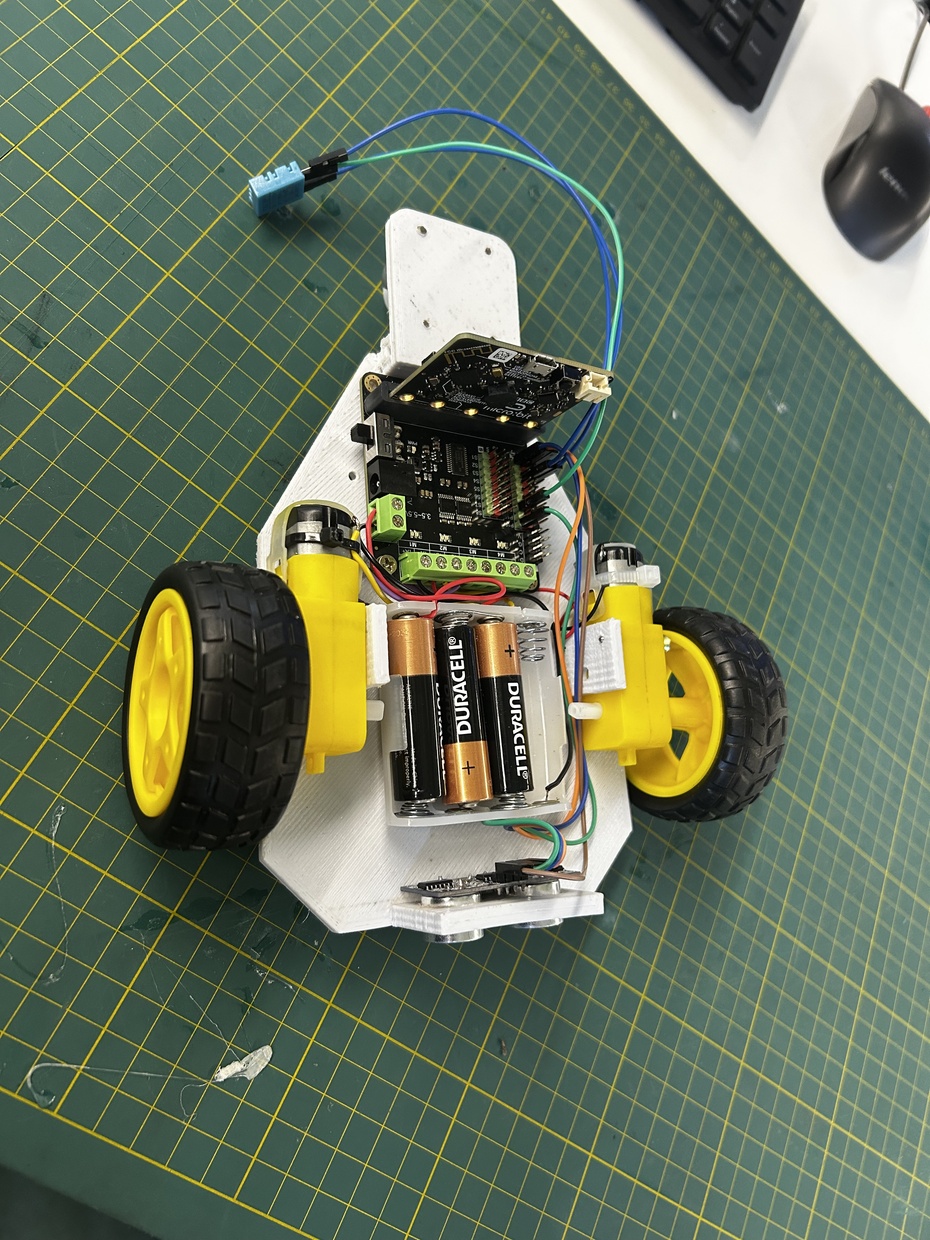 A construção mecânica do robô foi realizada a partir de um chassi desenvolvido em material leve ( Impresso em 3D ), com o objetivo de garantir resistência estrutural e baixo peso. O sistema de locomoção adotado consiste em duas rodas laterais acopladas a motores DC, permitindo a movimentação do robô. 
    Os componentes eletrônicos foram organizados de forma estratégica sobre o chassi, para facilitar o acesso e a conexão dos  módulos. A alimentação do sistema é feita por um suporte de pilhas, fixado na região central, contribuindo para a estabilidade ao manter o centro de massa equilibrado.
    O sensor DHT11 foi instalado na parte traseira do robô ( região da calda ) para que ficasse em posição elevada e externa à estrutura principal, garantindo maior exposição ao ambiente, e dados mais precisos. A fixação dos componentes foi realizada por meio de suportes e parafusos, assegurando firmeza durante a operação.

Observação: Apesar do desempenho estrutural, percebe-se a necessidade de atentar-se para a organização dos cabos, a fim de evitar interferências mecânicas durante o funcionamento do robô.