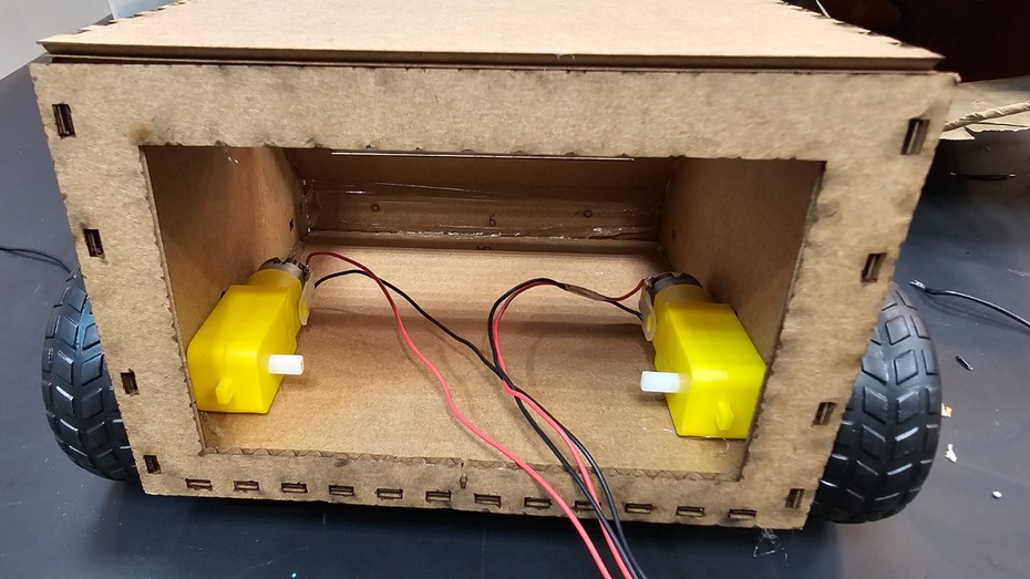 Com cuidado, segure o motor e encaixe as rodas.