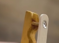 Cole, usando super cola, o palito na parte interna do pregador (lado do mordedor que não foi cortado) na mesma posição que a lente.