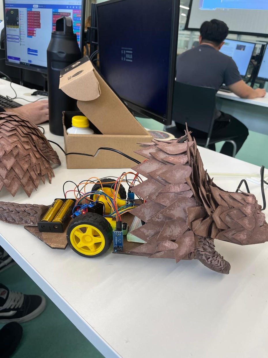 Com a estrutura física finalizada nos deslocamos para a parte eletrônica do projeto, onde iriamos programar os comandos e ações do nosso robô. O Micro:bit tinha a função de processar os comandos de rádio, já a Ponte H L928N controlaria os motores DC, para realizar os códigos utilizamos o Tinkercad. 

Programamos as conexões principais, então o P1/P2 que seria responsável pela Direção do Motor Esquerdo (IN1/IN2), o P13/P14 pela Direção do Motor Direito (IN3/IN4) e o P8/P9 pelo Controle de Velocidade (ENA/ENB). Depois foram os botões onde os Botões A/B seriam responsáveis separadamente de movimentos específicos, a junção dos dois (A+B) a deslocação frontal e o Logotipo pela Parada do movimento. Além disso, três sensores também foram utilizados que seria o MH Sensor Series (TCRT5000) para a luminosidade, o Sensor DHT11 para a temperatura e umidade e o Sensor Ultrassônico HCSR04 para a distância.