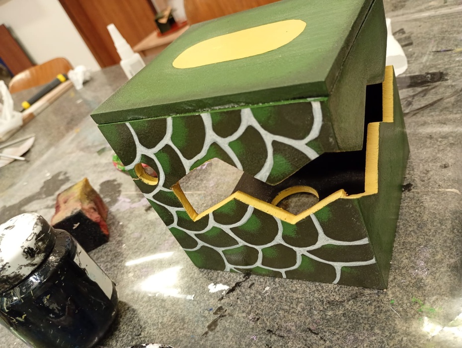 Para finalizar a luminária de dragão, pinte todas as superfícies externas conforme seu estilo e preferência, garantindo um acabamento que valorize o design. 

Lembre-se de pintar toda a parte interna da luminária com tinta preta, pois isso ajudará a destacar a lâmpada quando estiver acesa, criando um efeito visual mais impactante. 

Certifique-se de aplicar a tinta de forma uniforme e deixar secar completamente antes de usar a luminária.